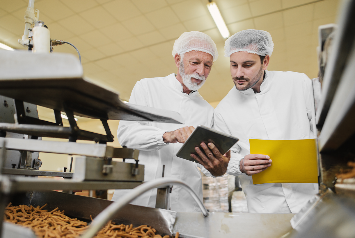 Two Men Examining Documents in Food Manufacturing Plant