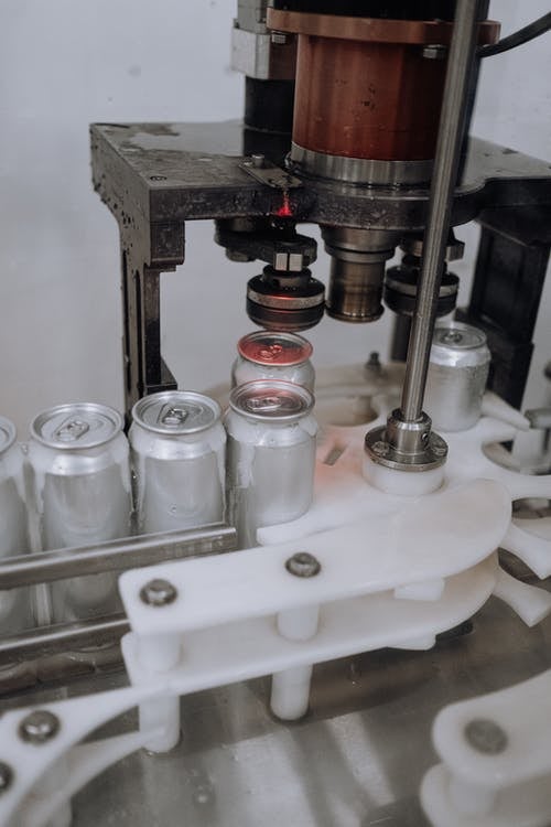 cans being sealed in factory DemandCaster