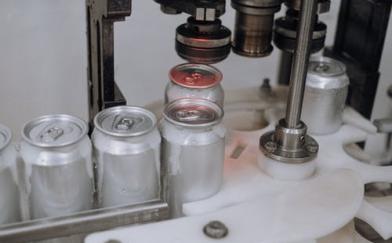 cans being sealed in factory DemandCaster