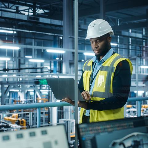 Manufacturer with Laptop on Plant Floor